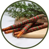 Red and green decorated pretzel rods covered in chocolate.