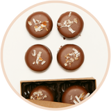 Coconut truffles with coconut flakes in a 4 piece chocolate box.