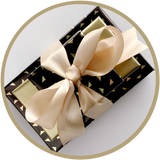Classy small gift bundle of boxes of chocolate wrapped in gold satin ribbon. 