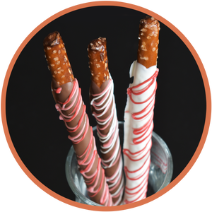 Chocolate dipped pretzel rods decorated with red, pink, white, and chocolate for Valentines Day.